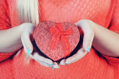 Kırmızı kalp şeklinde kutu onun elinde yakın çekim