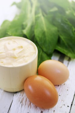 Taze kuzukulağı, yumurta ve ekşi krema bir beyaz tahta üzerinde