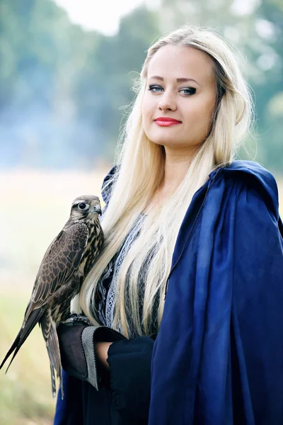 Blond Kvinna Blå Hooded Cloak Håller Falk Armen — Stockfoto