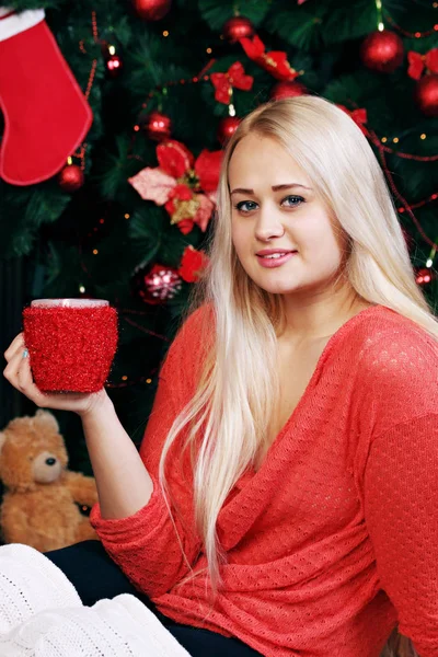 温かい飲み物を飲んで クリスマス ツリーの近くの女性 — ストック写真