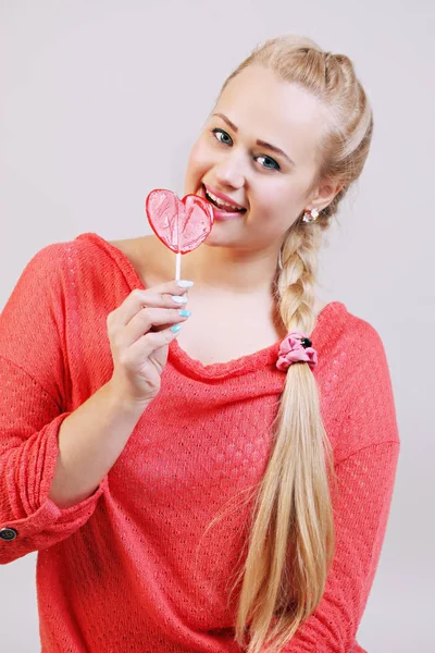 年轻美丽的金发女子捧着一根棒棒糖 — 图库照片