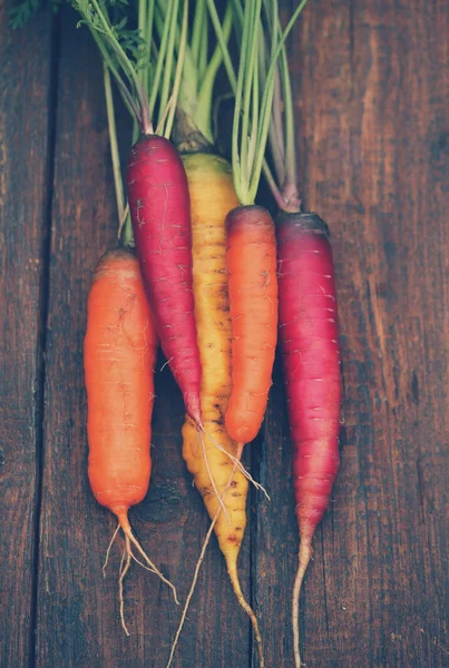 juicy colored carrots on a wooden table