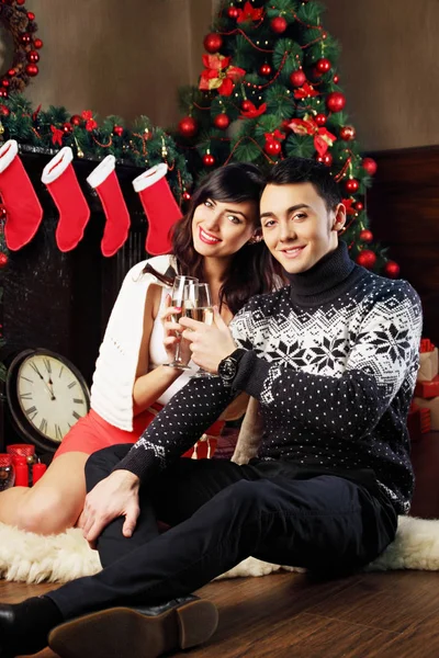 クリスマス 暗い室内ではシャンパンのグラスと若い美しいカップル — ストック写真