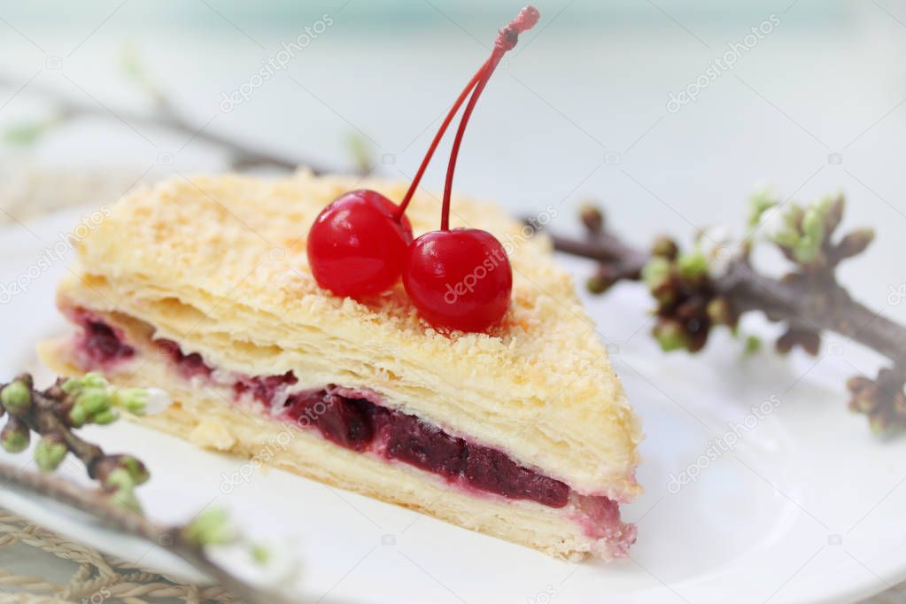 Napoleon cake with cherries on a plate