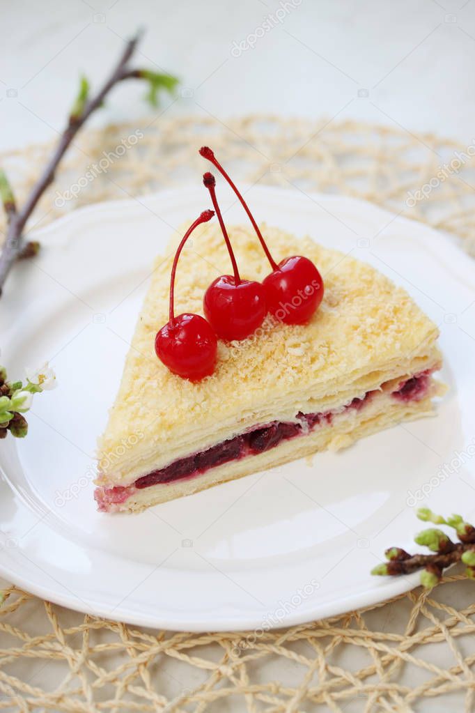 Napoleon cake with cherries on a plate