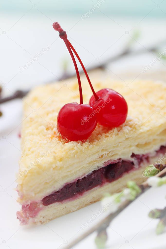 Napoleon cake with cherries on a plate