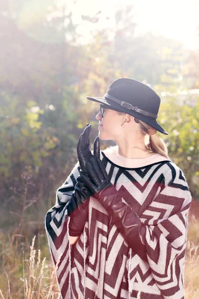 Женщина в пончо, шляпе и длинных перчатках — стоковое фото