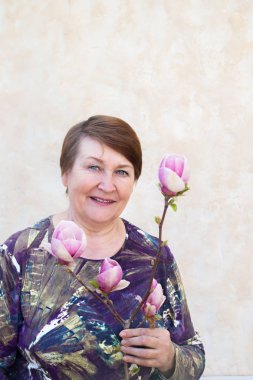 Yaşlı bir kadın bir manolya bir dalı tutan