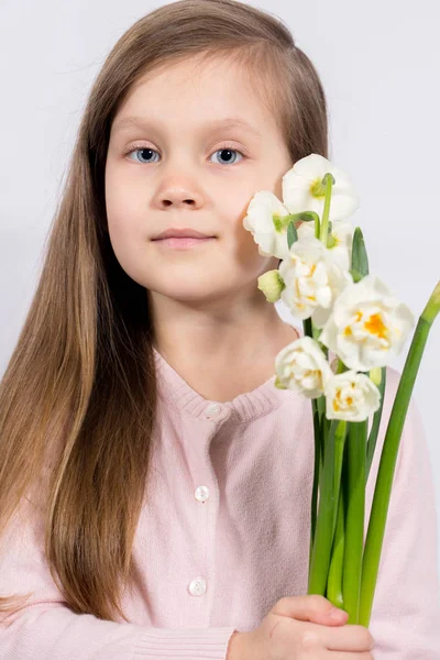 Menina segurando narcisos — Fotografia de Stock