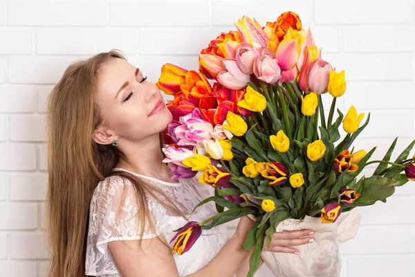 Pretty girl sniffs flowers — Stock Photo, Image