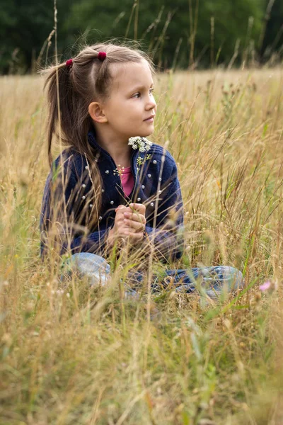 Dromerige meisje in een veld — Stockfoto