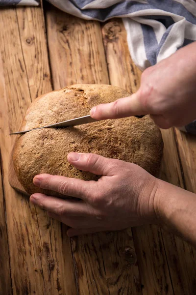 Человек режет хлеб — стоковое фото