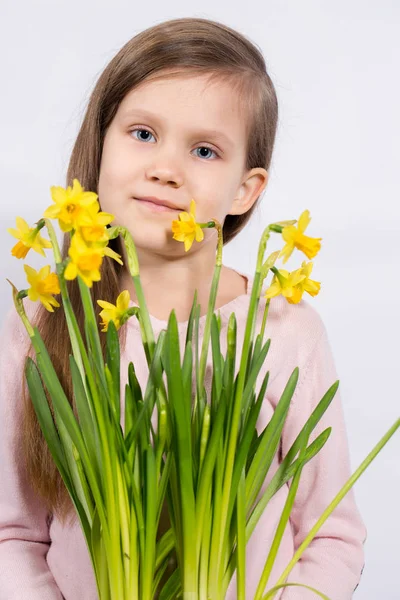 Menina com um buquê de narcisos — Fotografia de Stock