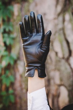 Kadın ellerinde siyah eldivenler.
