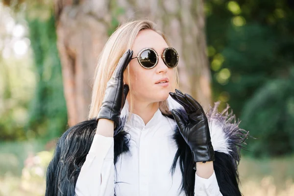 Женщина регулирует солнечные очки — стоковое фото