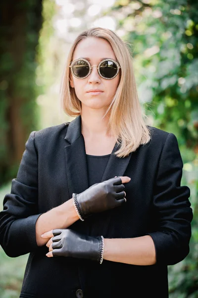 Красивая блондинка в черной куртке и перчатках с цепью — стоковое фото
