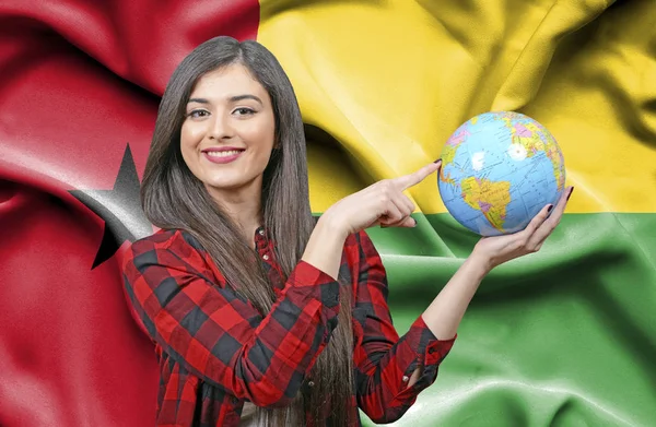 ギニアビサウの国旗に対して地球を保持若い女性観光客 — ストック写真