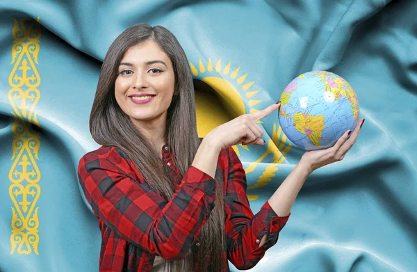 カザフスタンの旗に対して地球を保持若い女性観光客 — ストック写真