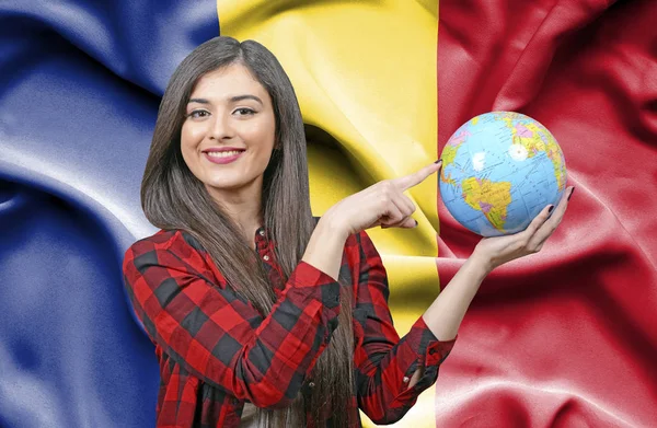 ルーマニアの旗に対して地球を保持若い女性観光客 — ストック写真