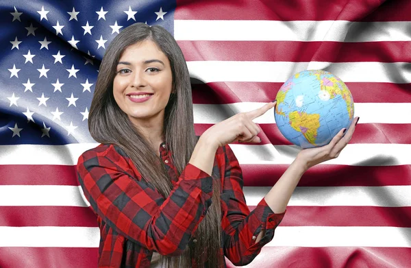 Молодая Туристка Держит Земной Глобус Против Флага Соединенных Штатов Америки — стоковое фото