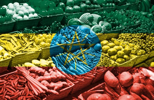 Variety of fresh fruits and vegetables against national flag of Ethiopia