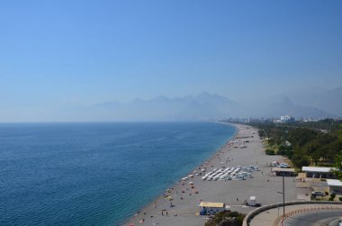 Deniz beach Antalya, Türkiye'nin bölgedeki dağlar arka plan üzerinde. Üstten görünüm güneşli bir günde. Yüzme ve kuma rahatlatıcı insanlar