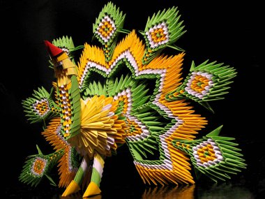 Kağıt tavus kuşu yeşil, sarı ve beyaz siyah bir zemin üzerine Modüler origami tekniğinde yapılmış bir kırmızı gaga ile figürü. El yapımı kuş