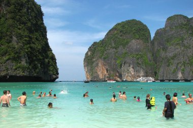 Maya Bay, Tayland - 7 Aralık 2013: Turist ve Maya Bay Phi Phi Islands ünlü sahilde tekne. Turistler beyaz Maya Bay kumsalı ve turkuaz lagün suların keyfini çıkarın