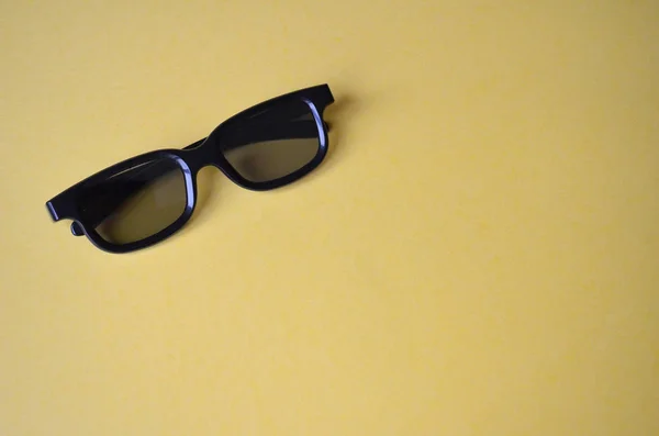 노란색 바탕에 검은색 플라스틱 안경입니다 선글라스 영화관을 — 스톡 사진