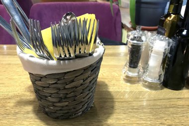 Hasır sepet çatal ve sarı peçete ahşap bir masa üzerinde ile 