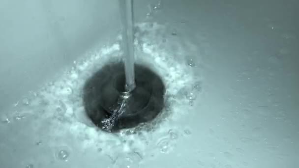 白いセラミック洗面台の金属栓の上に注ぐ水道水のジェット機のクローズアップ 水の滝と泡 — ストック動画