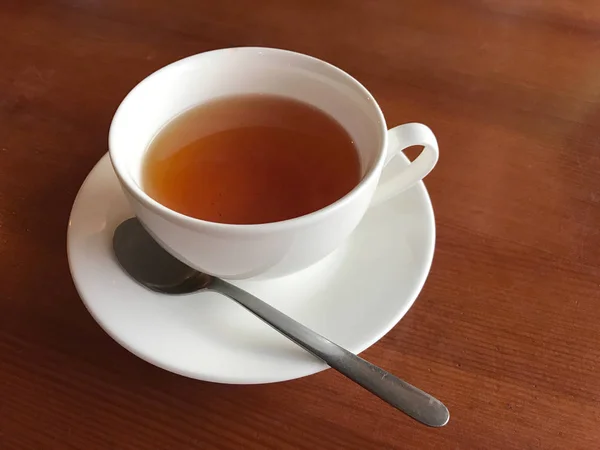 Чашка с черным чаем на деревянном столе — стоковое фото