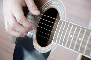 Gitarın iplerini toplayan bir erkek elin yakın çekim