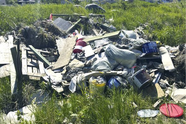 Куча строительного мусора на зеленой поляне

