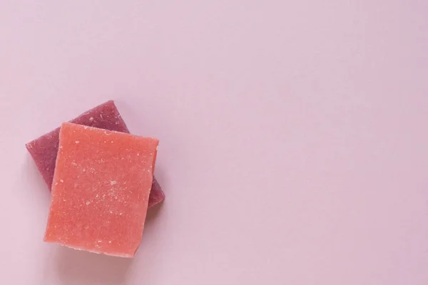 Πολύχρωμα κομμάτια από φυσικό χειροποίητο βιολογικό σαπούνι σε ροζ Wi Εικόνα Αρχείου