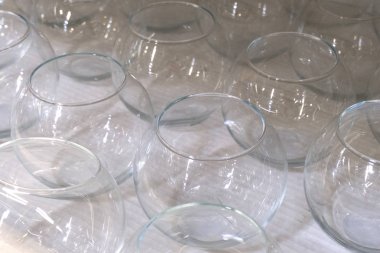 Kapaksız birkaç sıra şeffaf boş cam kap.