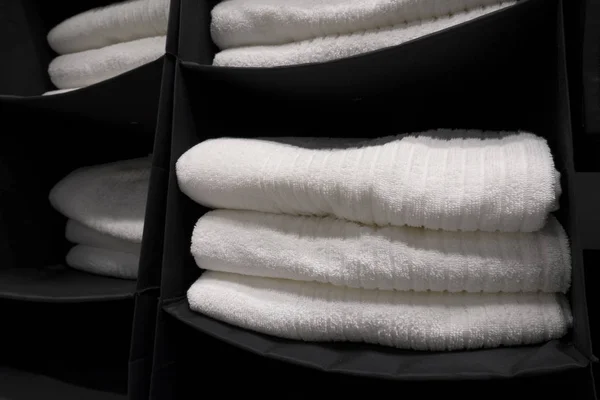 Pile di asciugamani di spugna bianca su ripiani appesi neri. Concetto di — Foto Stock