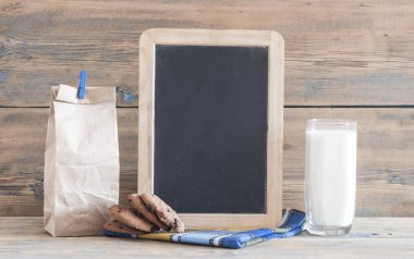 Çikolatalı kurabiye, cam bardak süt rustik ahşap zemin üzerine