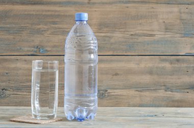 Plastik su şişesi ve su cam ahşap tablo.