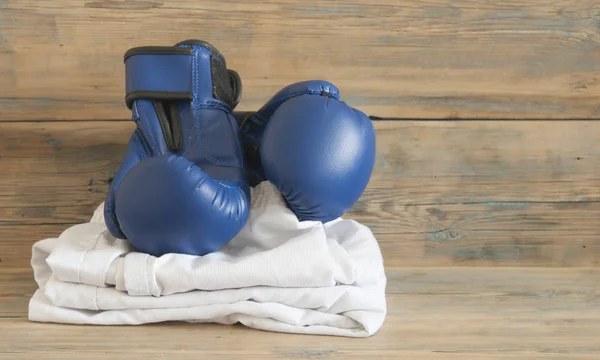 set Taekwondo equipment on a wooden background stock photos. Sports, martial arts. Protective equipment for fight in full contact