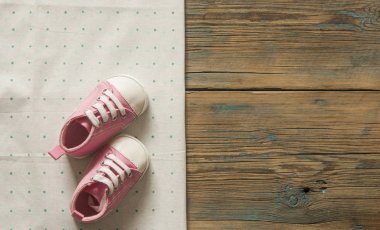 Tatlı küçük bebek patiği yeşil polka dot arka planda, üstten görünüm 