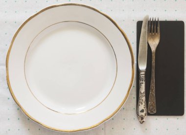 Vintage gümüş eşya çatal ve bıçak bir polka dot tableclot üzerinde beyaz boş levha