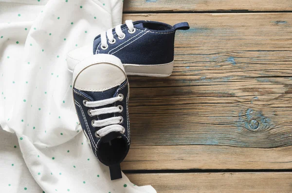 Tatlı küçük bebek patiği yeşil polka dot arka planda, üstten görünüm 