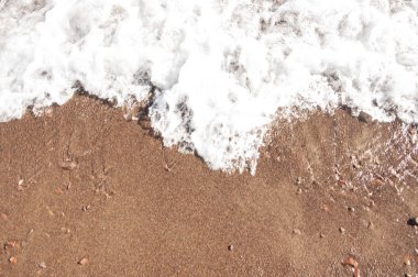 Sandy beach ile temizleyin yumuşak dalga beyaz köpük köpük ile güneşli günde