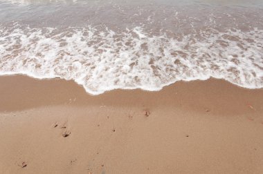 Sandy beach ile temizleyin yumuşak dalga beyaz köpük köpük ile güneşli günde