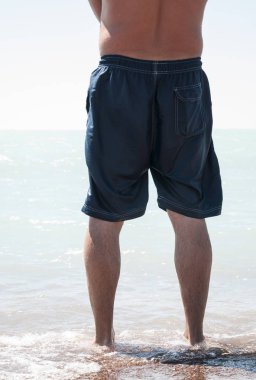 Adam çıplak ayakla kum plajında denize yürüme Hayır gömlek ile