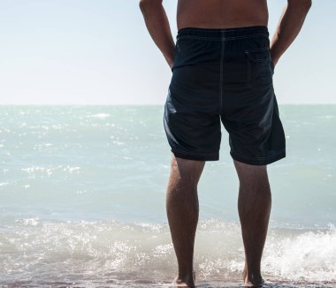 Adam çıplak ayakla kum plajında denize yürüme Hayır gömlek ile