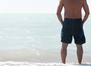 Adam çıplak ayakla kum plajında denize yürüme Hayır gömlek ile