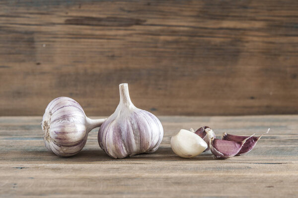 Purple garlic. Bulbs of garlic on old wooden surface. 