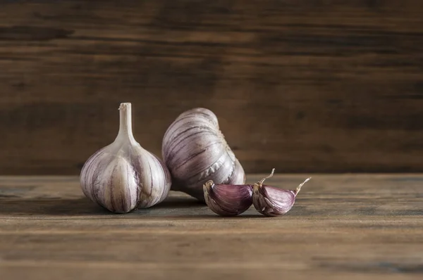 Purple garlic. Bulbs of garlic on old wooden surface.